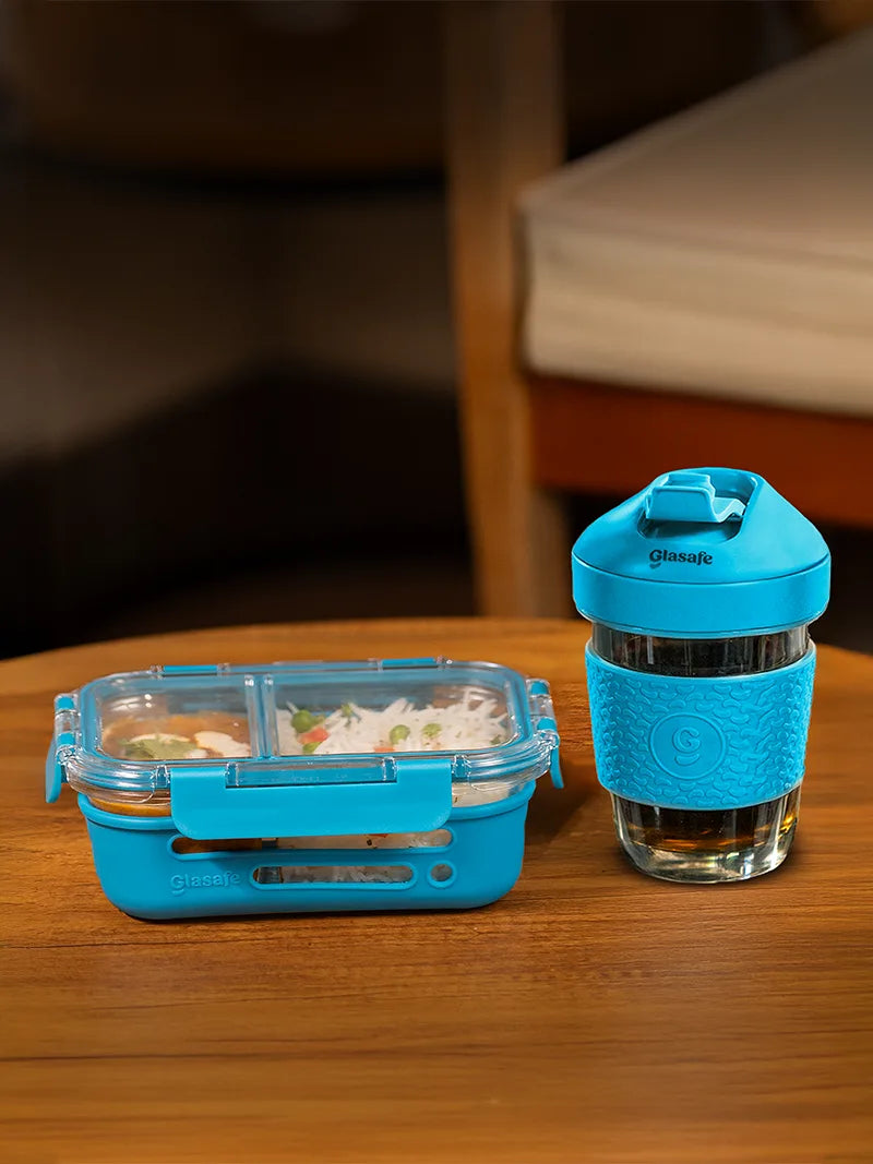 Blue food container and glass with lid on a wooden surface